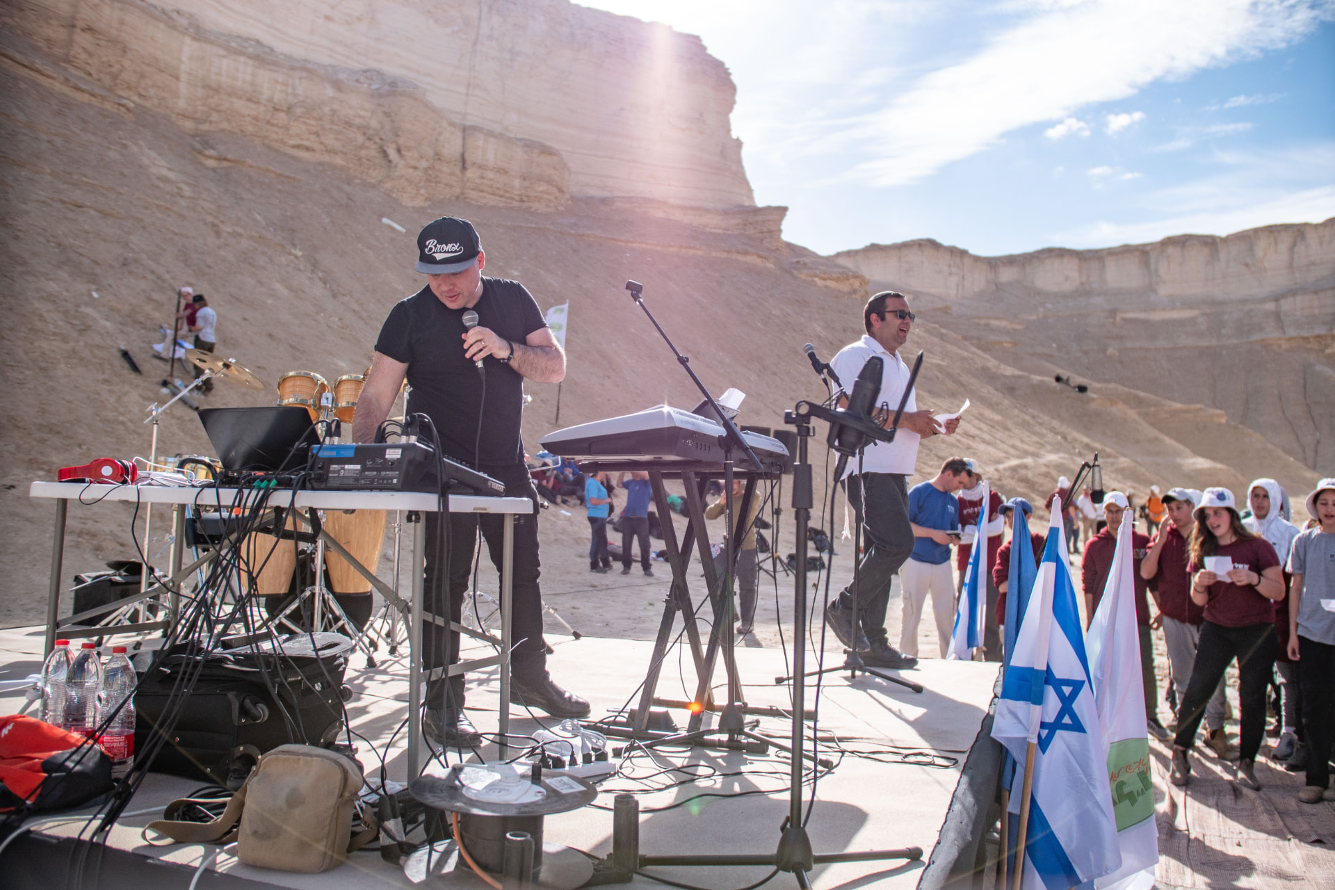צוות בצוותא עם מיקרופונים וקלידים בהפקת שירת המונים במדבר