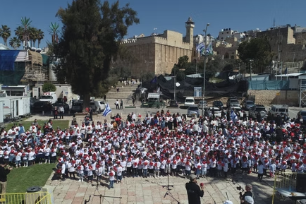 קהל גדול משתתף בשירת המונים בחוץ בירושלים עם דגלי ישראל ובלונים אדומים